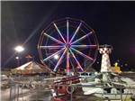 Carnival rides lit up at night nearby at CAMP PEDRO CAMPGROUND - thumbnail