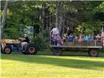 A man on a tractor pulling people for a ride at COUNTRY ROADS CAMPGROUND - thumbnail