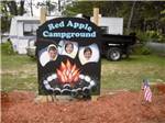 Three kids sticking their heads thru a sign so they look like marshmallows roasting over a fire at RED APPLE CAMPGROUND - thumbnail