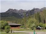 Looking at one of the buildings with mountains in the background at FAIRMONT HOT SPRINGS RESORT - thumbnail