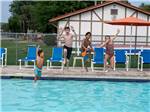 A group of kids jumping into the swimming pool at FRANKENMUTH YOGI BEAR'S JELLYSTONE PARK CAMP-RESORT - thumbnail