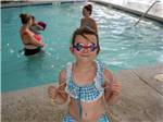 A girl with goggles on by the pool at FRANKENMUTH YOGI BEAR'S JELLYSTONE PARK CAMP-RESORT - thumbnail