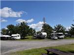 A row of motorhomes and trailers parked at ANICINABE PARK - thumbnail