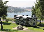 View larger image of A Class A RV parked alongside a couple of picnic benches at BONELLI BLUFFS RV RESORT  CAMPGROUND image #4
