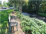 A park bench looking at the stream at HOLIDAY RV PARK - thumbnail