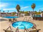 View larger image of A large community fire pit surrounded by blue chairs at OCEANSIDE RV RESORT image #6