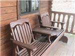 A siding park bench on the deck of a rental cabin at PARADISE LAKE AND CAMPGROUND - thumbnail
