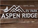 A wooden fence with the park name on it at ASPEN RIDGE RV PARK - thumbnail