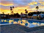 View larger image of The swimming pool area at dusk at SUNDANCE RV RESORT image #1
