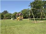 View larger image of Playground with swings slide and more at SCOTTS FAMILY RV-PARK CAMPGROUND image #3