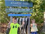 Kids standing in front of a catch of the day sign at ATLANTIC OAKS - thumbnail