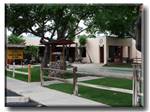 Grassy area with trees and wishing well at PRINCE OF TUCSON RV PARK - thumbnail