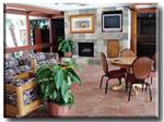 Indoor seating with couches, table and chairs and fireplace  at PRINCE OF TUCSON RV PARK - thumbnail