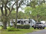 View larger image of A travel trailer under a tree at SOUTHERN AIRE RV RESORT image #9