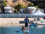 View larger image of A couple of people paddle boarding at NEWPORT DUNES WATERFRONT RESORT  MARINA image #3