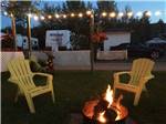 Two chairs sitting next to a fire at CAMPING PANORAMIC - thumbnail