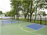 Basketball court with green surface next to a pickleball court at COUNTRY ACRES CAMPGROUND - thumbnail