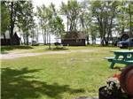 A grassy RV site with a picnic table at GLENROCK COTTAGES & TRAILER PARK - thumbnail