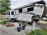 A fifth wheel trailer parked in a gravel site at LOUISVILLE NORTH CAMPGROUND - thumbnail