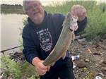View larger image of A man holding a fish at JUNIPERS RESERVOIR RV RESORT image #12
