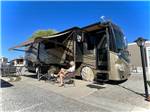 Woman reading under RV awning at Westwind RV & Golf Resort - thumbnail