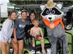 Kids on a golf cart with the raccoon mascot at BEYONDER GETAWAY AT WHEELER LAKE - thumbnail