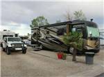 A Class A motorhome parked in a gravel spot at MCARTHUR'S TEMPLE VIEW RV RESORT - thumbnail