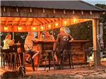 A group of people sitting under the pavilion at Van Hoy Farms Family Campground - thumbnail