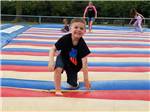 A boy having fun on the jumping pillow at CAMELOT CAMPGROUND QUAD CITIES - thumbnail