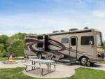 Parked RV with fire pit at site Sun Retreats Fond du Lac East - thumbnail