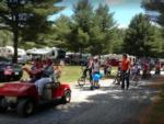A couple riding on a red golf cart at TWO RIVERS CAMPGROUND - thumbnail