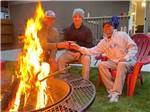 Three men sitting next to a fire pit at RIVERSIDE RV AND CAMPER PARK - thumbnail