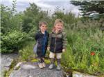 Two boys standing on a rock at RIVERSIDE RV AND CAMPER PARK - thumbnail