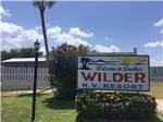 View larger image of Entrance sign next to white fence at ALAMO ROSE RV RESORT image #1