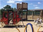 View larger image of The wooden playground equipment at BANDERA PIONEER RV RIVER RESORT image #5