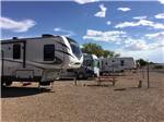 Fifth-wheels and motorhome under blue sky at OK RV PARK - thumbnail