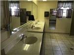 View larger image of A bathroom area with oval sinks and mirror at WANDERLUST RV PARK image #6