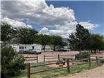Campground with wood-fenced lawn in middle at ROYAL VIEW RV PARK - thumbnail