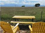 Two yellow chairs overlooking a field at FALCON MEADOW RV CAMPGROUND - thumbnail