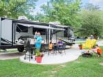 Parked RV and family sitting outside at RENFRO VALLEY KOA HOLIDAY - thumbnail