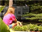 A lady sitting down next to a tree at LEDGEVIEW RV PARK - thumbnail