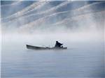 A fisherman on a boat on a foggy lake at TOPAZ LODGE RV PARK & CASINO - thumbnail