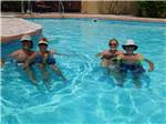 View larger image of Two couples in the swimming pool at FIG TREE RV RESORT image #1