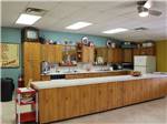 View larger image of A long kitchen counter with fridge and cabinets at ELK CREEK RV PARK image #10