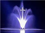 The fountain with a cross lit up a night at LEISURE ACRES CAMPGROUND - thumbnail