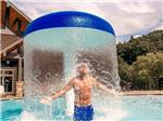 A boy standing under a water fall feature at PIGEON FORGE RV RESORT - thumbnail