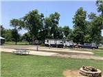 A travel trailer parked next to some empty sites at PECAN GROVE RV PARK - thumbnail