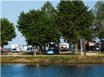 RVs with trees by the water at Tom Sawyer's RV Park - thumbnail