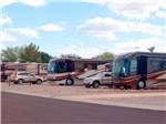 Row of big rig RVs on gravel sites at MISSION VIEW RV RESORT - thumbnail
