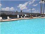 View larger image of Lounge chairs around the pool at TEXAS TRAILS RV RESORT image #10